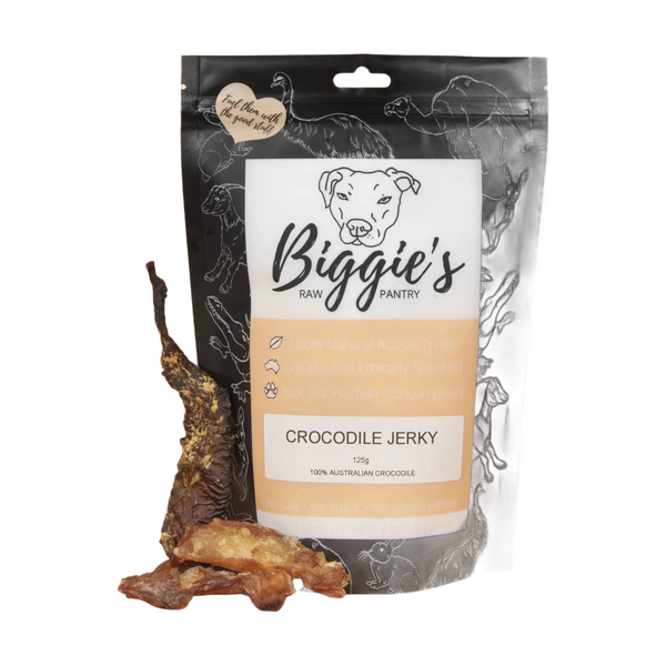 A package of Biggies Crocodile Jerky, featuring a black and orange design with information about the product, including its hypoallergenic properties and that it is made from 100% Australian crocodile.